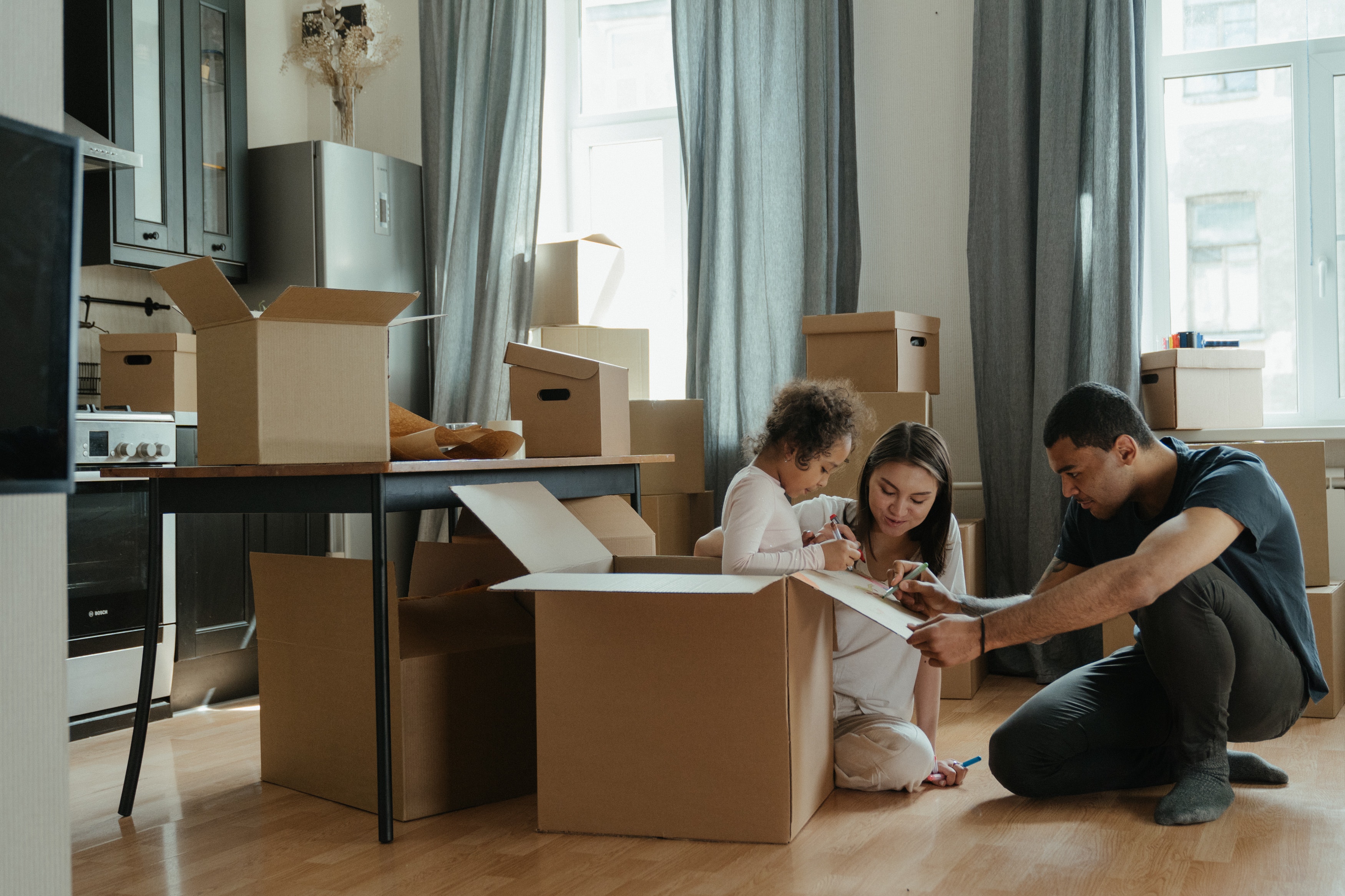 Moving house. Семья в квартире. Семья жилье. Семья распаковывает вещи.